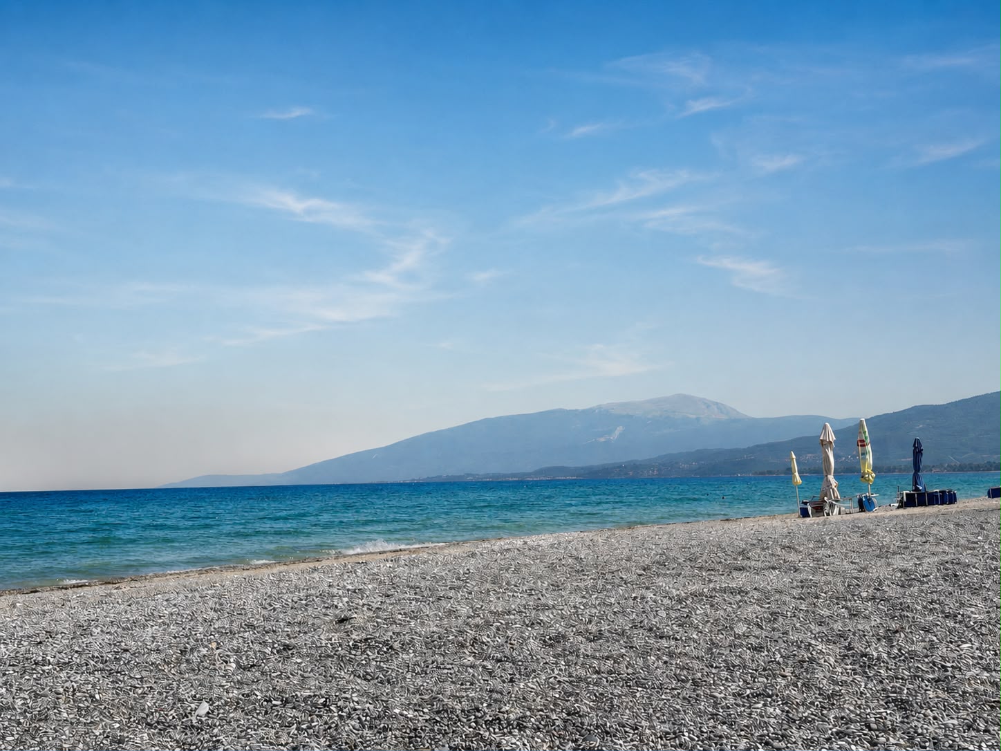 Olympus Riviera beach with clear blue sea and mountain views